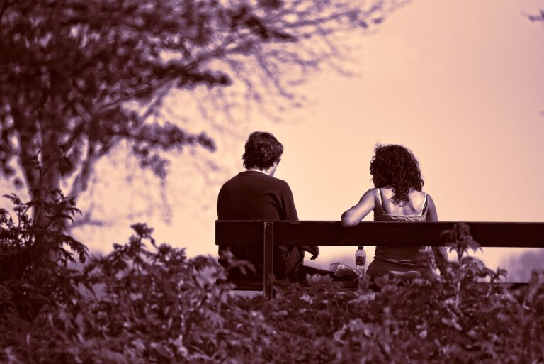 Two people sat chatting on a bench